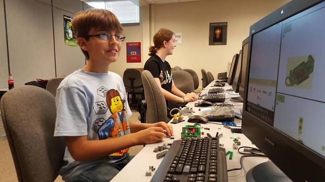 Boy sitting at computer coding lego robot. Boy sitting at computer coding lego robot.